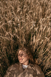 Portrait young woman lies on a rye field