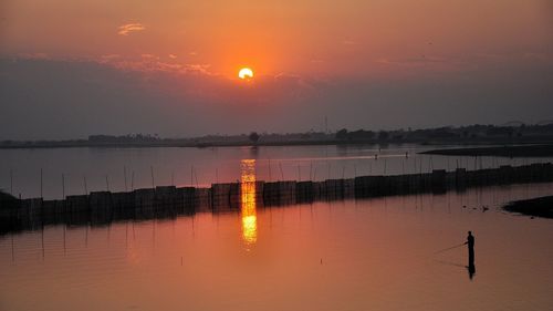 Scenic view of lake against sky during sunset