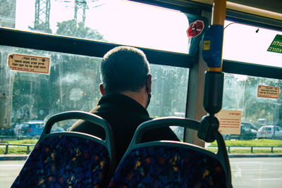 Rear view of man sitting in bus