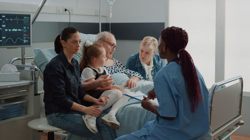 Family sitting by patient in hospital