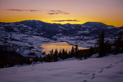 Scenic view of snow covered mountains against sky during sunset