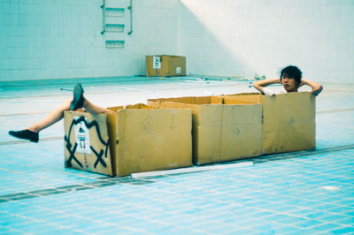 Man sitting in box in swimming pool