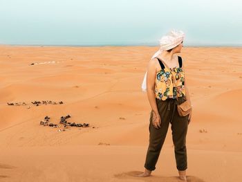 Full length of man standing on sand at beach against sky