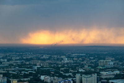 High angle view of illuminated cityscape against sky during sunset