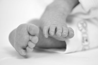 Low section of baby sleeping on bed