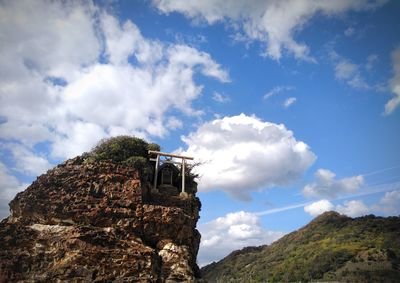 Low angle view of rocks on mountain against sky
