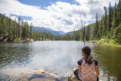 Rear view of woman standing in lake