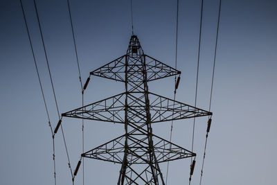 Low angle view of electricity pylon against clear sky