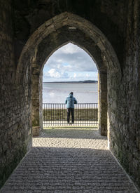 Rear view of woman standing at archway