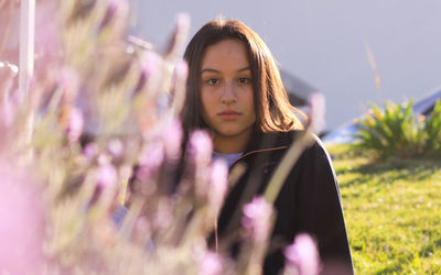 Portrait of woman against pink flowers