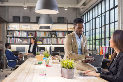 Colleagues in a boardroom discussion, seated at a table together, 