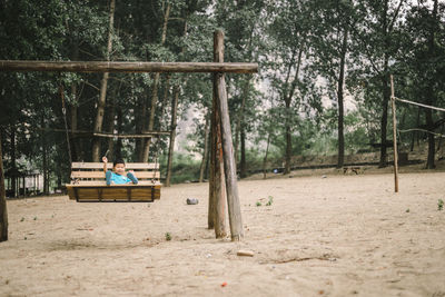 Man sitting on bench in forest