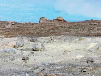 Rock formations on shore against sky