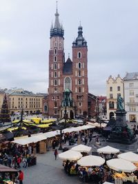 People on street against buildings in city