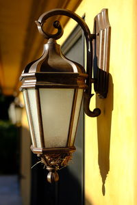 Close-up of electric lamp hanging against wall