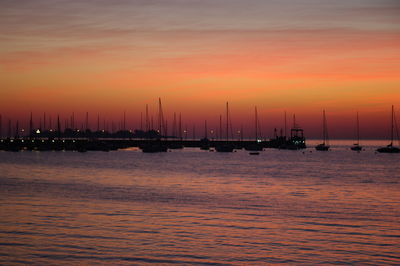 Silhouette ship sailing on sea against sky during sunset