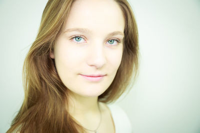 Close-up portrait of a smiling young woman over white background