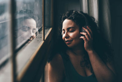 Close-up of young woman looking through window