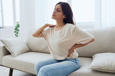 Young woman sitting on sofa at home