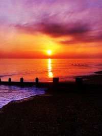 Scenic view of sea against dramatic sky during sunset