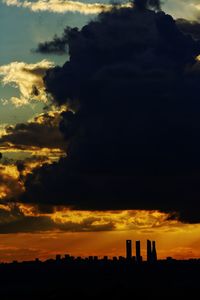 Silhouette city against sky during sunset