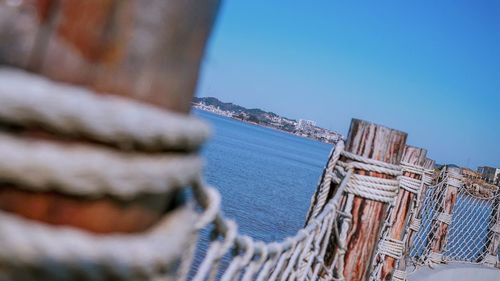 Close-up of sailboat against sea against clear blue sky