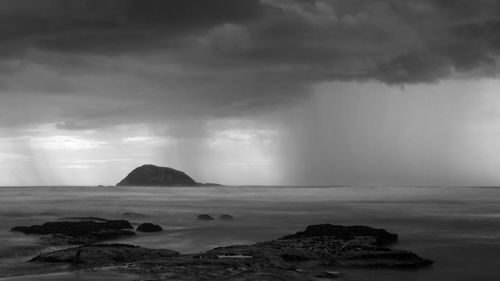 Scenic view of rocks on sea against sky