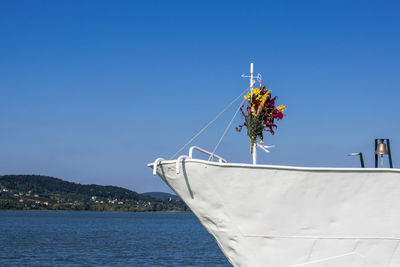 Sailboat in sea against clear blue sky