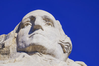 Low angle view of statue against clear blue sky