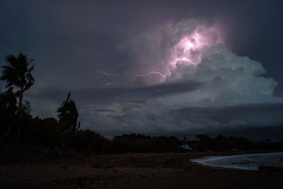 Lightning over landscape against sky at night