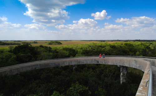 Man standing at observation tower against cloudy sky