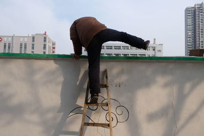 Man in city against sky