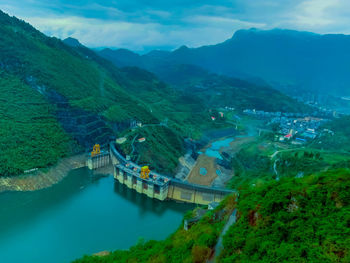 High angle view of river amidst mountains against sky