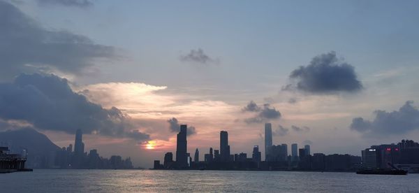Panoramic view of sea and buildings against sky during sunset