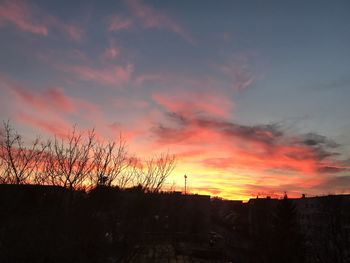 Silhouette landscape against dramatic sky during sunset