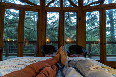 Low section of friends relaxing on bed in hotel room