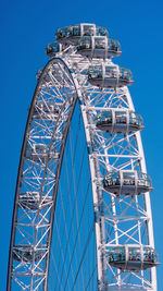 Low angle view of ferris wheel against blue sky