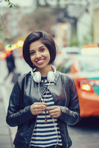 Portrait of smiling young woman standing on street