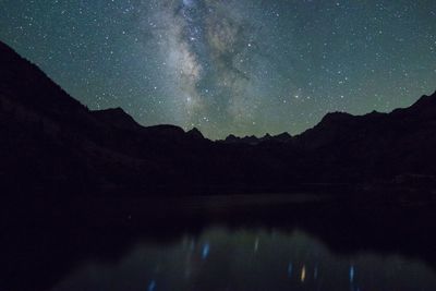 Scenic view of silhouette mountains against sky at night