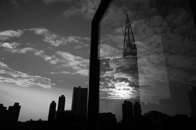 Low angle view of skyscrapers against cloudy sky