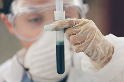 Close-up of scientist examining liquid in test tube