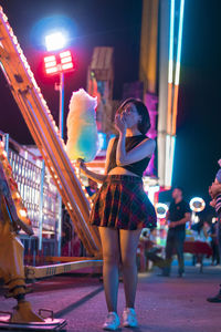 Woman holding cotton candy while standing in event