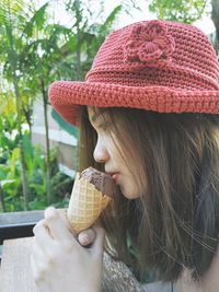 Woman having ice cream against plants