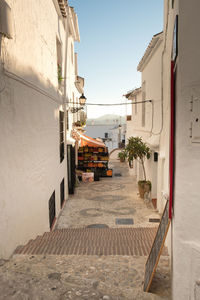 Narrow alley amidst buildings in city against sky