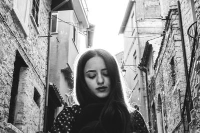 Portrait of young woman standing against sky