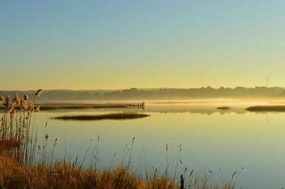 Scenic view of calm lake at sunset