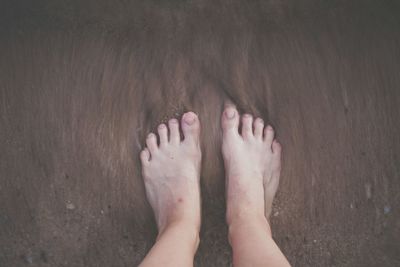 Low section of woman standing on tiled floor