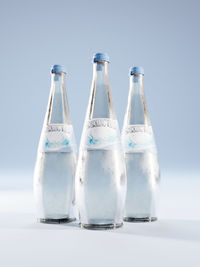 3d rendering of three sparkling water glass bottles with fake label on blue background