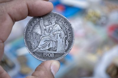 Cropped hand of person holding coin