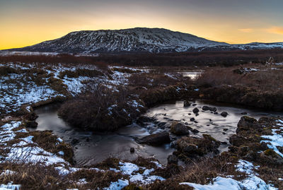 Scenic view of snowcapped mountains against sky during sunset